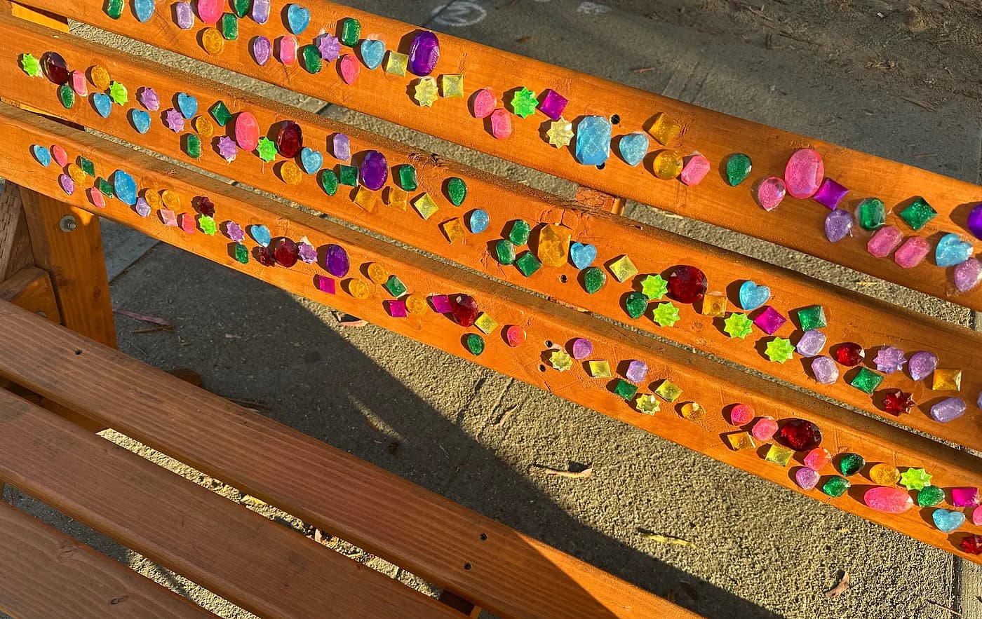 a bench with colorful jewels adorned on it down uc berkeley's college avenue