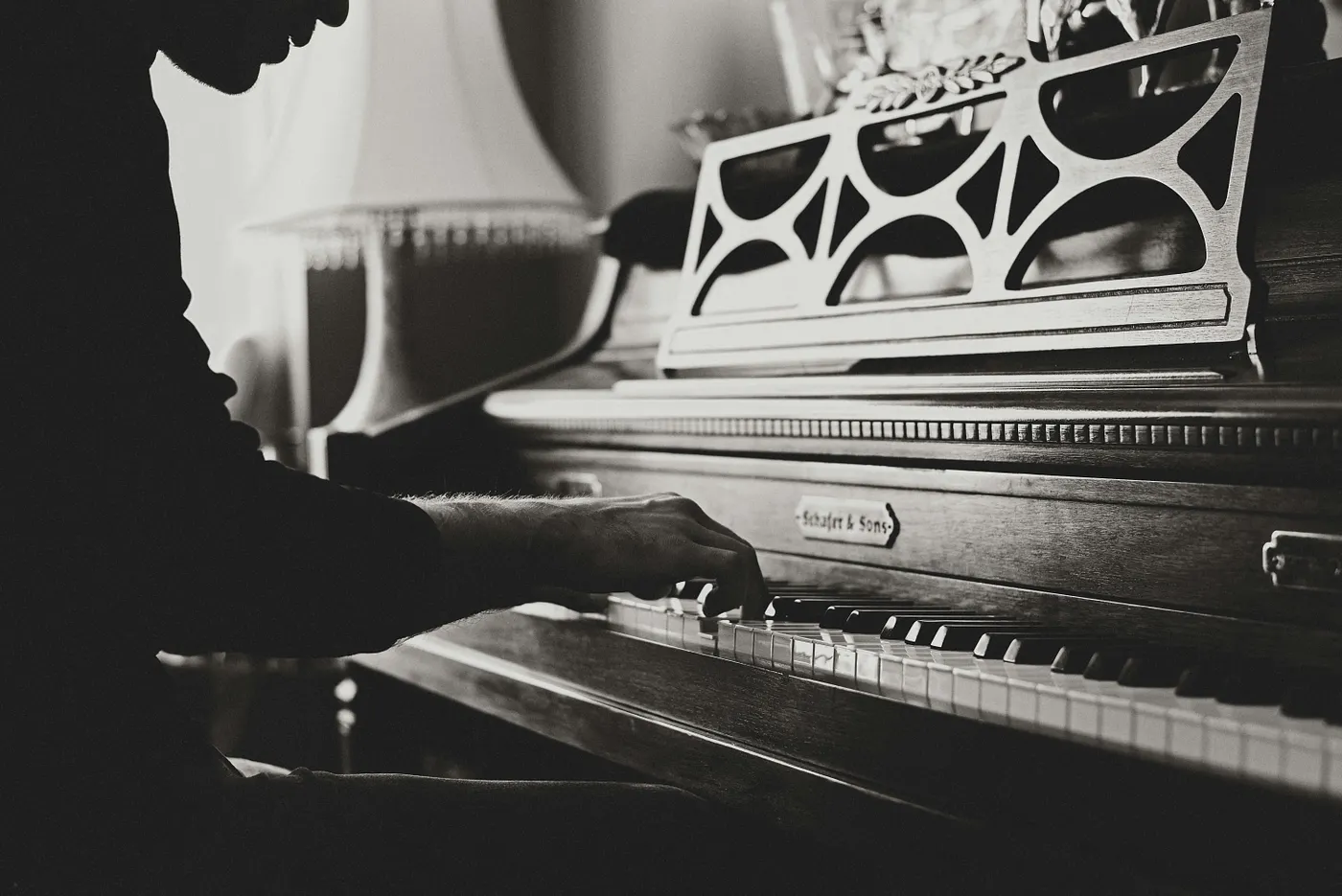 black-and-white photo of a person playing a piano